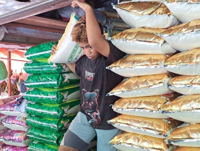 Sumber Foto : (Kompas.com/Darsil Yahya M), Pegawai toko beras di Pasar Terong Makassar, Sulsel saat mengangkat beras untuk pelanggannya, Selasa (13/2/2024).