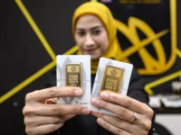 Sumber Foto : Jawapos, Petugas menunjukkan emas Antam di Butik Emas Logam Mulia PT. Aneka Tambang (Antam) di kantor pusat Jalan TB. Simatupang, Jakarta, Salman Toyibi.