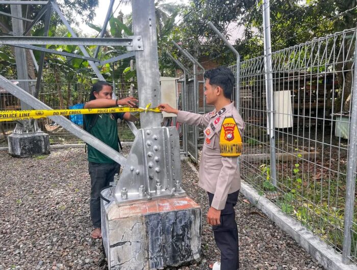 Anggota kepolisian sedang memasang garis polisi (police line) di lokasi tower telekomunikasi tempat terjadinya pencurian baterai di Dusun Paga, Desa Mekkatta Selatan, Kecamatan Malunda, Kabupaten Majene. Kamis (14/8/2025)