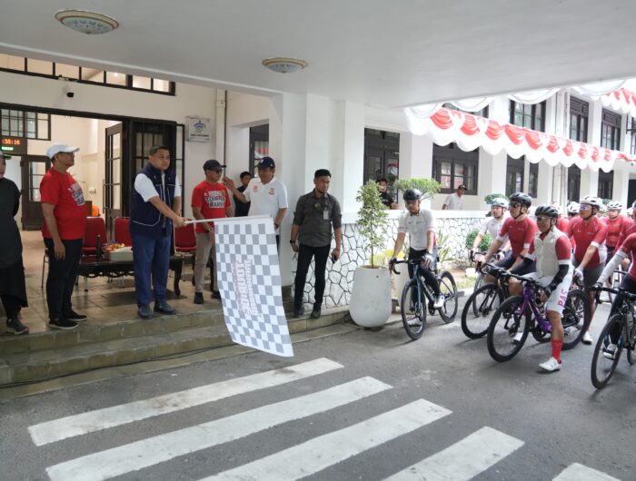 Wali Kota Makassar, Munafri Arifuddin, mengibaskan bendera start sebagai tanda pelepasan peserta Touring Sepeda Merdeka De Barru 2025 di halaman Balai Kota Makassar, Minggu (24/8/2025).