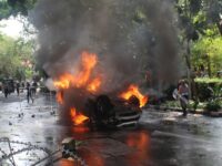 Istimewa, Mobil terbakar setelah terbalik di tengah kerusuhan di kawasan perkotaan.
