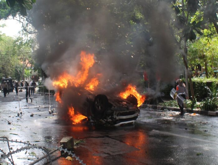 Istimewa, Mobil terbakar setelah terbalik di tengah kerusuhan di kawasan perkotaan.
